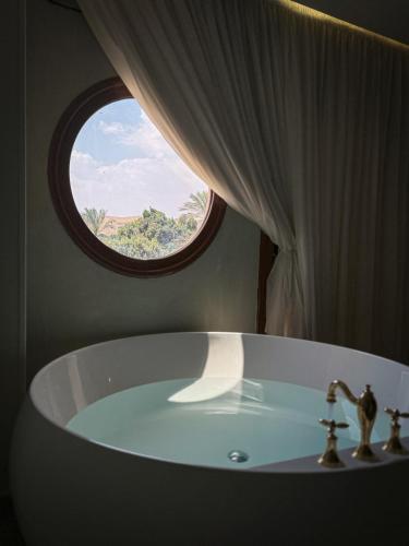 a bathroom with a bath tub with a window at Almas Pyramids Hotel in Cairo