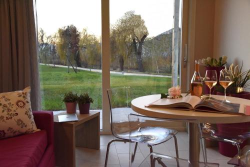 salon ze stołem i dużym oknem w obiekcie Costa Verde Natura w mieście Clusane sul Lago