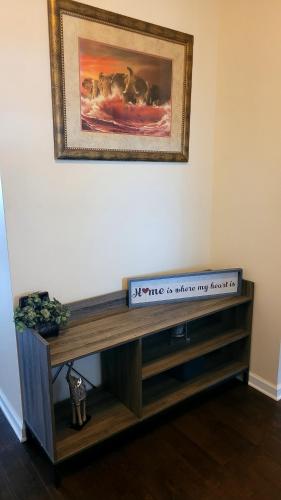 a wooden entertainment center with a picture on the wall at Cozy SFH for Active Adults in Middletown