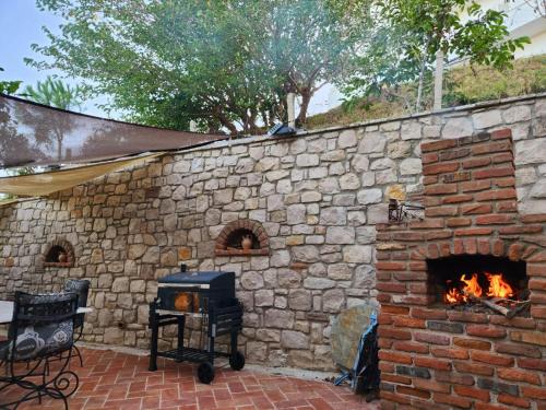 a stone wall with a brick oven in a patio at Villa Sunrise in Draçi