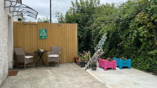 a patio with chairs and plants and a fence at The Éire Escape Studio in Slane