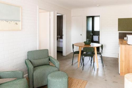 a living room with a table and a chair at The Lodge At The Denmark Hotel in Denmark