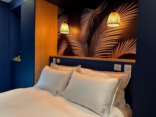 a bedroom with a bed with two lights above it at Les Rubys, spas privatifs in Tarcenay