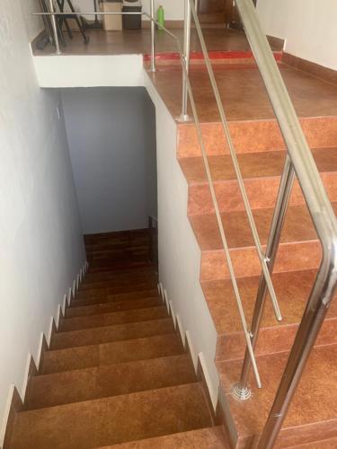 a staircase with wood floors and a metal railing at Ruby in Kottayam