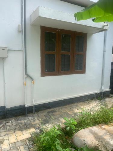 a house with a window on the side of it at Ruby in Kottayam