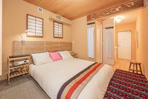 a bedroom with a large bed and a stool at Hotel Ginnan in Tokyo