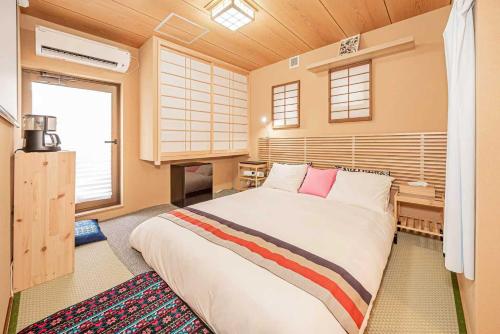 a bedroom with a large bed and a desk at Hotel Ginnan in Tokyo