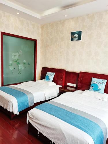 a hotel room with two beds and a painting on the wall at Emeishan Moon Bay Hotel in Emeishan