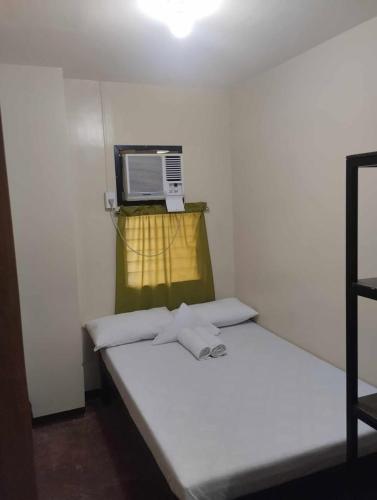 a small room with a bed with a microwave on the wall at ACHIEVERS DORMITORY in Cebu City
