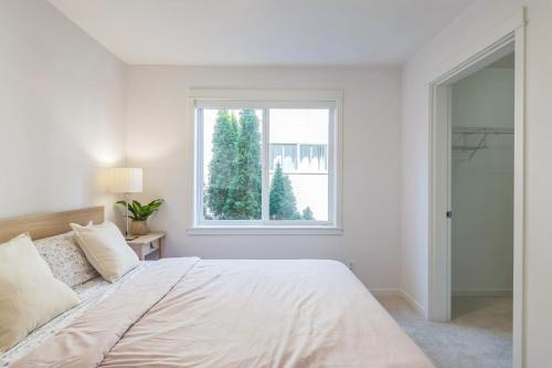 a white bedroom with a bed and a window at Walkable Seattle Gem Close To Everything condo in Seattle