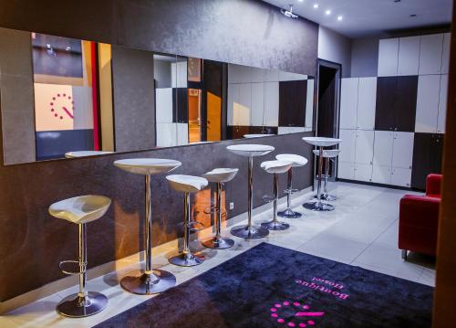 a bar with a row of stools in a room at Boutique Hostel in Łódź