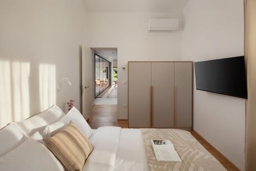 ロヴィニにあるCasa Mariaの白いソファとテレビ付きの白いベッドルーム