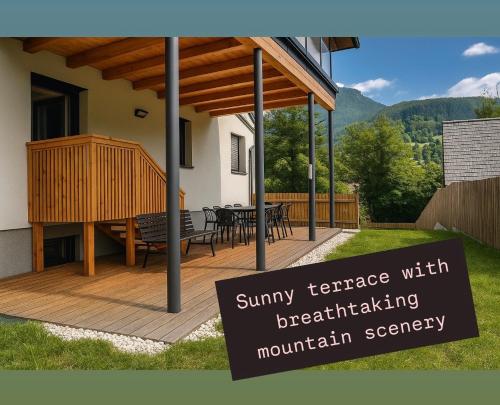 a house with a wooden deck with a table at Sepperls Stubn Apartment - PETS no extra cost - Bad Goisern - 24-hours Self check-in in Bad Goisern