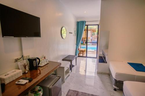 a living room with a bed and a tv on the wall at Selectum Mangrove Resort in Panglao