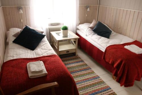 two beds in a small room with a table at Solsta Towers in Asarum