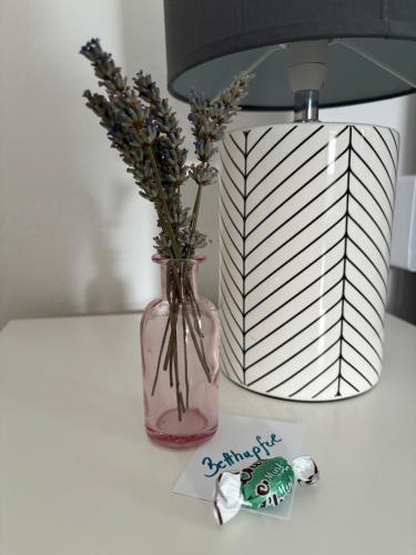 a table with a vase with flowers and a lamp at Ferienwohnung Auszeit Döbriach in Döbriach