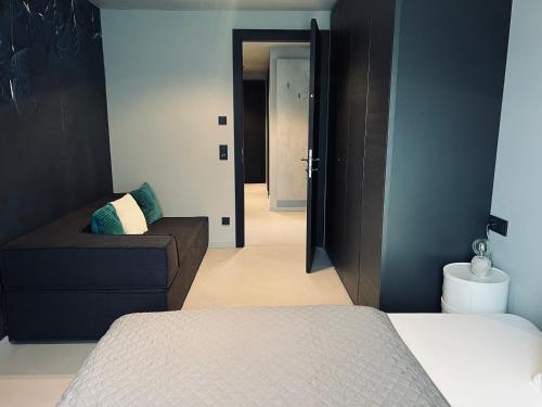 a bedroom with a bed and a couch and a door at GOING TRIPLE A apartments EAST in Going