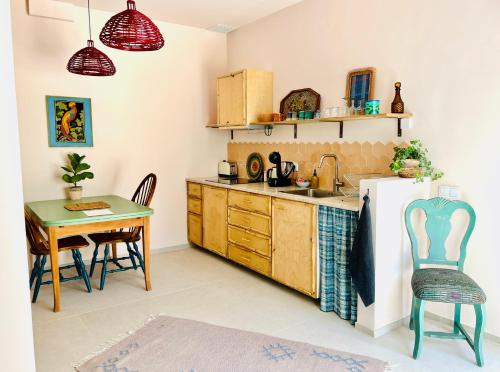 a kitchen with a table and a refrigerator at Studio Indigo in Aljezur