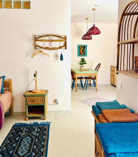 a room with a bed and a dining room with a table at Studio Indigo in Aljezur