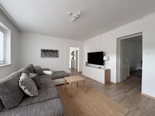 a living room with a couch and a tv at Ferienwohnung Auszeit Döbriach in Döbriach
