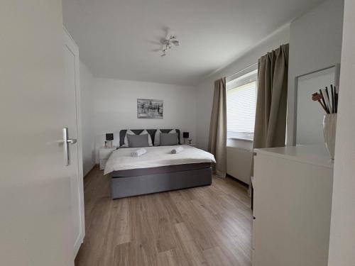a white bedroom with a bed and a window at Ferienwohnung Auszeit Döbriach in Döbriach