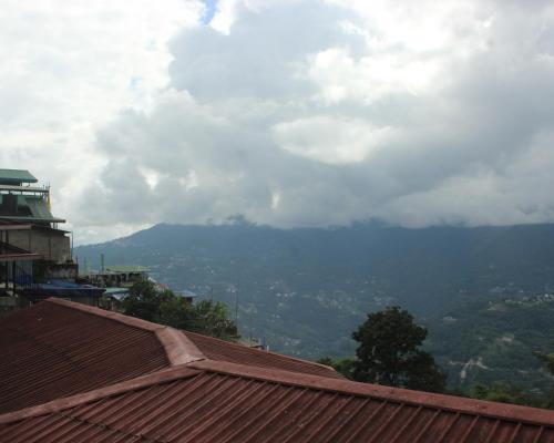 a view of a mountain from a roof of a house at Hotel Utpala in Gangtok
