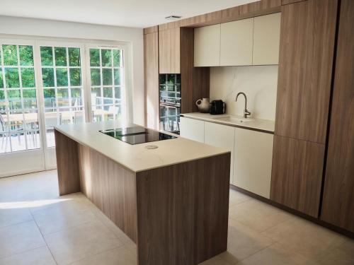 a kitchen with wooden cabinets and a counter top at Villa Les Rosiers private parking in Le Touquet-Paris-Plage