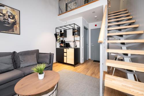 a living room with a couch and a table at Brand new Kalma Apartments in Tallinn