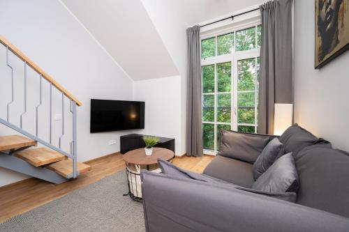 a living room with a couch and a tv at Brand new Kalma Apartments in Tallinn