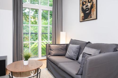 a living room with a couch and a table at Brand new Kalma Apartments in Tallinn