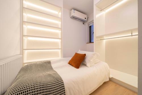 a bedroom with white walls and a bed with a pillow at Book and Bed-People's Square in Shanghai