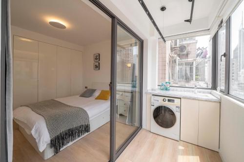 a bedroom with a bed and a washing machine at Book and Bed-People's Square in Shanghai