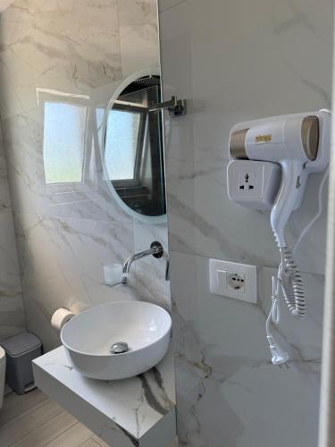 un bagno bianco con lavandino e specchio di Galaxy Hotel a Ksamil