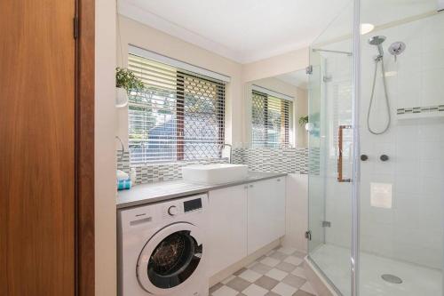 a bathroom with a washing machine and a sink at Duke Street Hideaway in Busselton