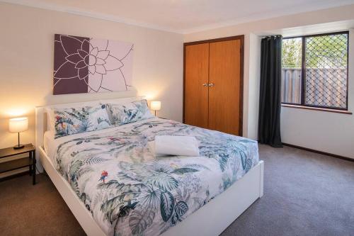 a bedroom with a bed with a laptop on it at Duke Street Hideaway in Busselton