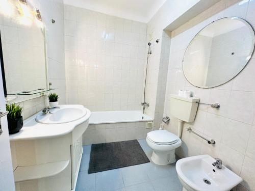 a bathroom with a sink and a toilet and a mirror at Luxury rooms next attractions and station in Lisbon