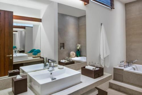 a bathroom with two sinks and a mirror at The Aviary Hotel in Siem Reap