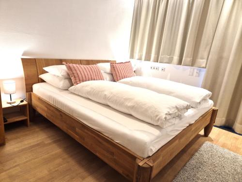 a bed with white sheets and pillows on it at Ferienwohnung Simonhof in Maria Alm am Steinernen Meer