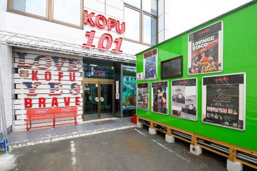 a green building with a sign on the side of it at space AJITO in Kofu