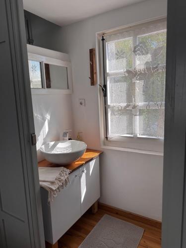 a bathroom with a sink and a window at Eden in Teos Pansiyon in Seferihisar