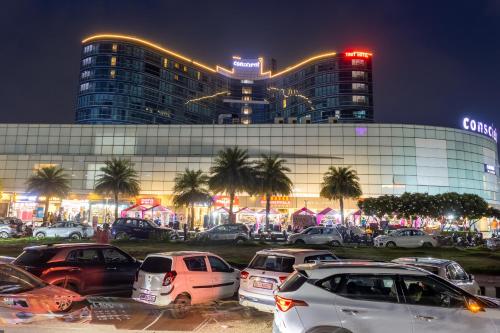 a parking lot with cars parked in front of a building at The Trot Hotel & Suites near Yashobhoomi Udyog vihar in Gurgaon