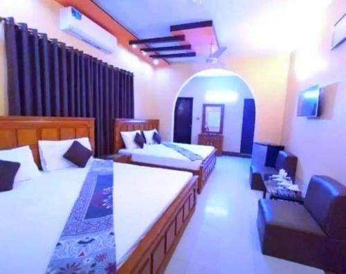 a bedroom with two beds and a couch in a room at Royal Residency Guest House Karachi in Karachi