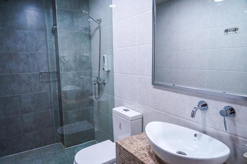 a bathroom with a shower and a sink and a toilet at Sayyoh Hotel in Tashkent