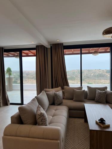 a living room with a couch and large windows at Cruiser Mogador Essaouira in Essaouira