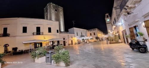 an empty city street at night with a clock tower at "Casa Simone" in Leverano