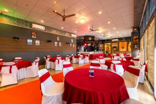 a banquet hall with red and white tables and chairs at The Trot Hotel & Suites near Yashobhoomi Udyog vihar in Gurgaon