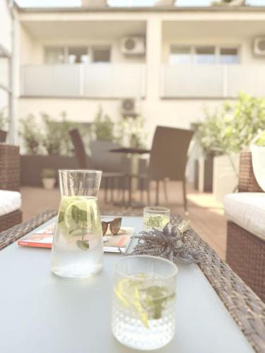 a table with a vase and two glasses on it at Villa Green in Sliač