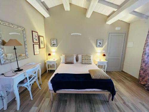 a bedroom with a bed and two tables and a mirror at Agriturismo Tenuta il Molino in Gabbro