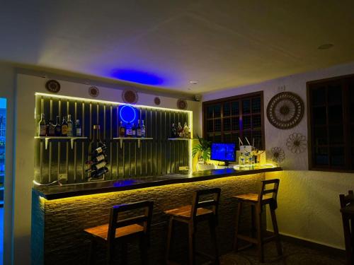 a bar in a restaurant with chairs and a blue light at Alona Garden Suites in Panglao