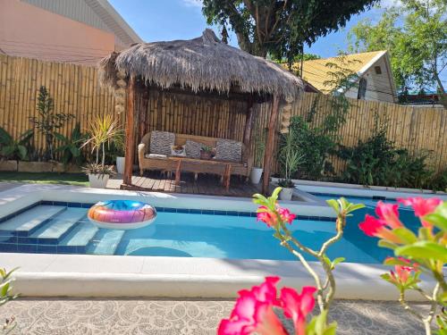 a pool with a gazebo with a bench in a backyard at Alona Garden Suites in Panglao
